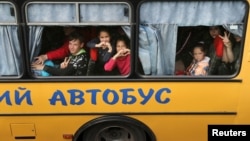 Children are evacuated from the Russian-occupied town of Kupyansk town on the outskirts of Kharkiv in May 2022.