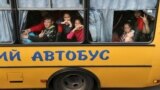 Children gesture as they are evacuated from the Russian-occupied town of Kupyansk town on the outskirts of Kharkiv, on May 30, 2022.