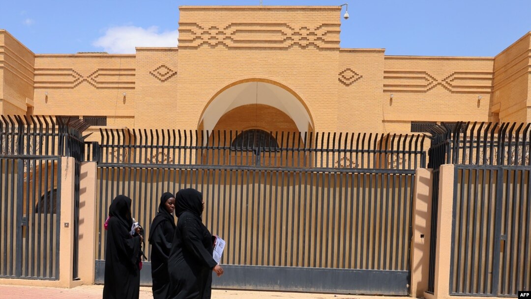 Women walk past the currently shuttered Iranian Embassy in the diplomatic quarter of the Saudi capital, Riyadh, on April 11.