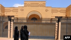 Women walk past the currently shuttered Iranian Embassy in the diplomatic quarter of the Saudi capital, Riyadh, on April 11. 
