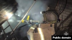 Un pompier încearcă să stingă incendiul după un atac cu drone în Herson, Ucraina. 20 decembrie.