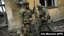 Ukrán katonák készülnek a frontvonalra a donbászi Bahmut városánál 2023. március 11-én