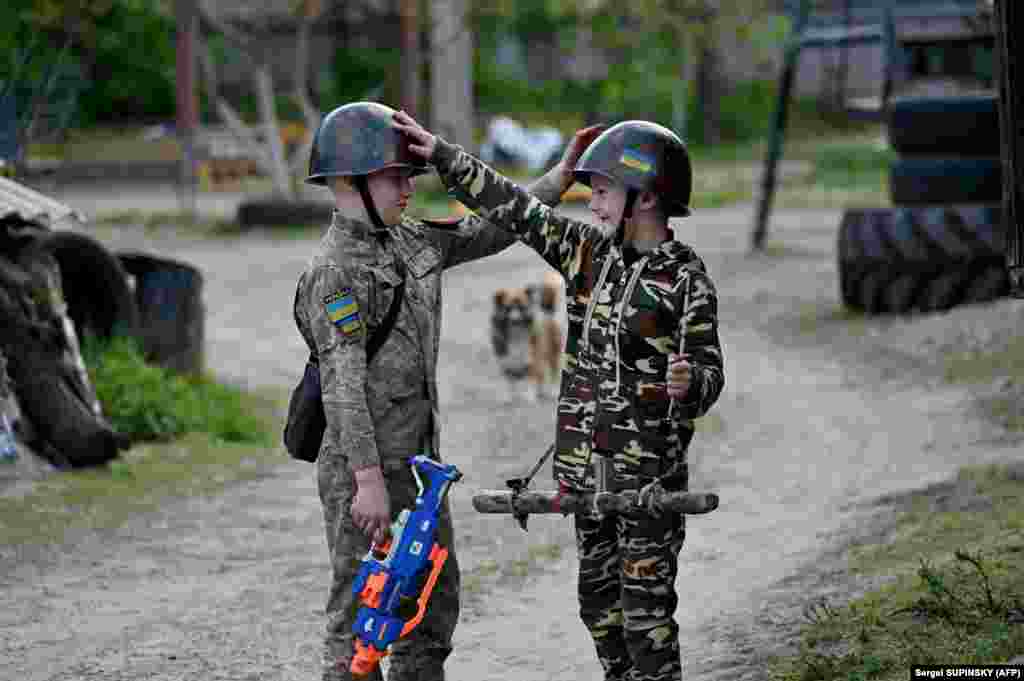 11 mai 2023, Stoyanka, lângă Kiev: Doi copii se joacă de-a războiul.