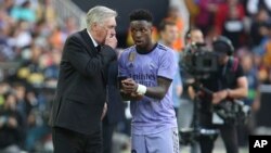 Antrenorul principal al echipei Real Madrid, Carlo Ancelotti, stânga, vorbește cu Vinicius Junior de la Real Madrid în timpul meciului de fotbal din La Liga spaniolă dintre Valencia și Real Madrid, pe stadionul Mestalla din Valencia, Spania, duminică, 21 mai 2023