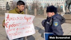 На кадре из видео — Темирлан Енсебек с плакатом перед монументом Независимости и сотрудник полиции. Алматы, 9 февраля 2024 года