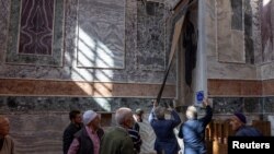 Vjernici gledaju prekrivene freske