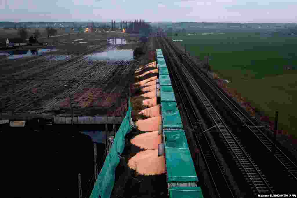 Piles of corn believed to have been exported from Ukraine lie on the ground next to train cars in the village of Kotomierz, in Poland&#39;s Kuyavian-Pomeranian region, on February 25 after protesters opened the wagons and dumped their contents.