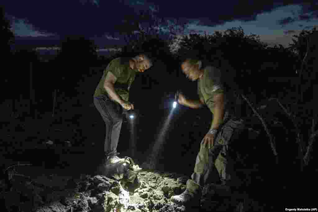 Ukrainian policemen look at a fragment of a rocket in a crater.&nbsp;Serhiy Dobriak, head of the Pokrovsk City Military Administration, reported that four people suffered minor injuries, including a 12-year-old child.