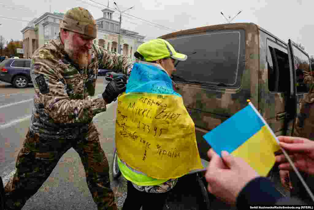 Український військовий підписує херсонцям прапори у день звільнення міста від російської окупації. Херсон, листопад 2022 року