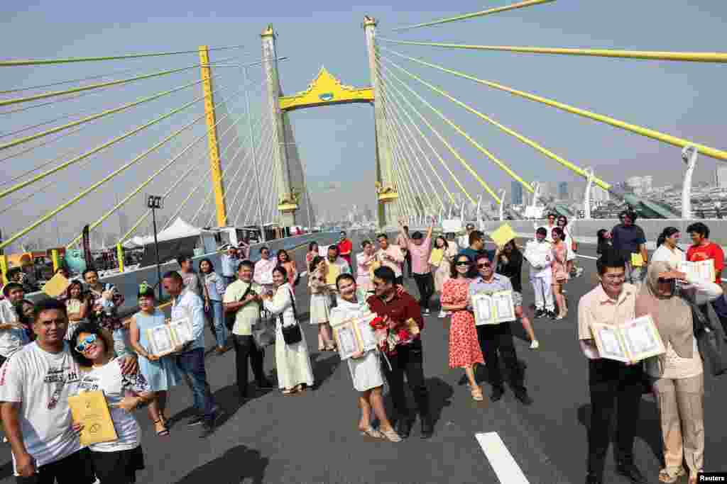 Parovi poziraju za fotografiju nakon što su dobili dozvolu za vjenčanje od službenika tokom proslave Valentinova na novoizgrađenom mostu paralelnom s mostom Rama IX u Bangkoku, Tajland