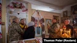 Ukrainian soldiers attend Mass at an Orthodox church near the front lines in the Donetsk region as Ukrainians prepare to celebrate their first Christmas according to a Western calendar.