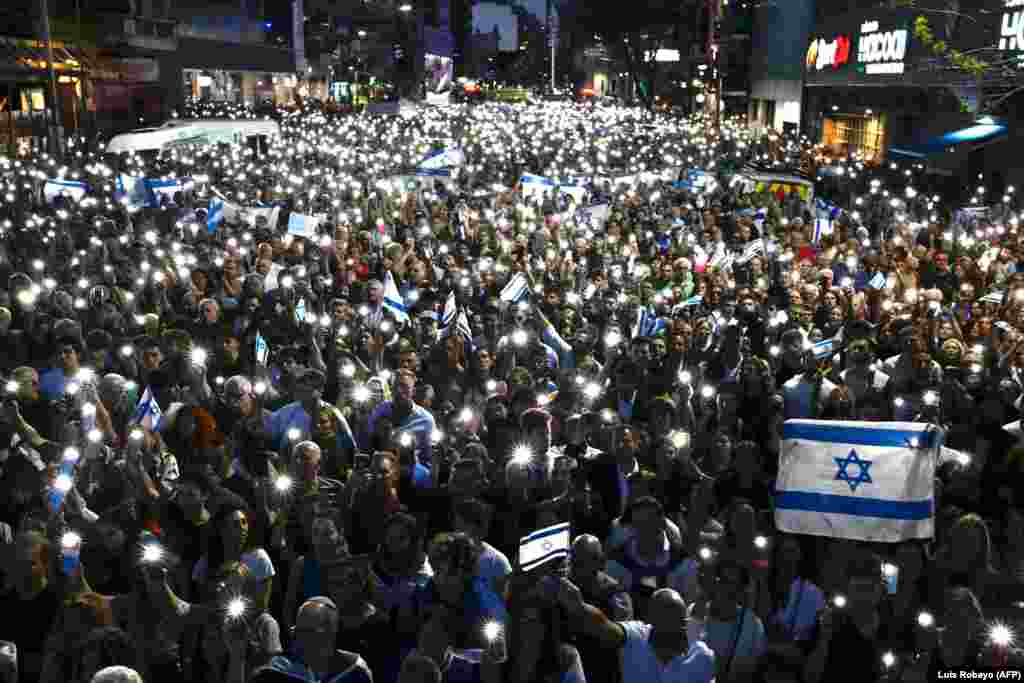 A tömeg mobiltelefonokat és izraeli zászlókat tart a magasba egy október 9-i Buenos Aires-i tüntetésen