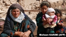 یک خانم با نواسه هایش در ولسوالی انجیل ولایت هرات که در اثر زلزله خانه شان ویران شده است. October 24, 2023