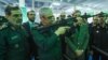 محمد باقری رئیس ستاد کل نیروهای مسلح (نفر وسط) در یک نمایشگاه نظامی اسلحه به دست گرفته است