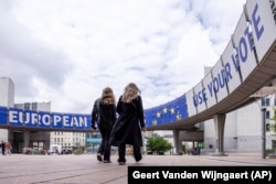Люди гуляють біля Європейського парламенту перед дебатами з головними кандидатами на виборах. 23 травня 2024 року