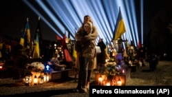 Луѓе се собраа на воените гробишта во Лвив на настанот „светлина на меморијата“ во чест оние кои загинаа борејќи се против руската инвазија, 23 февруари 2023 година.