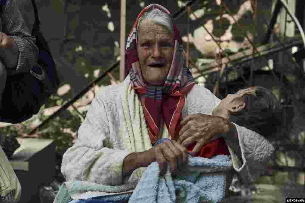 An elderly woman holds a disabled relative as they are evacuated from a flooded neighborhood in Kherson, Ukraine.