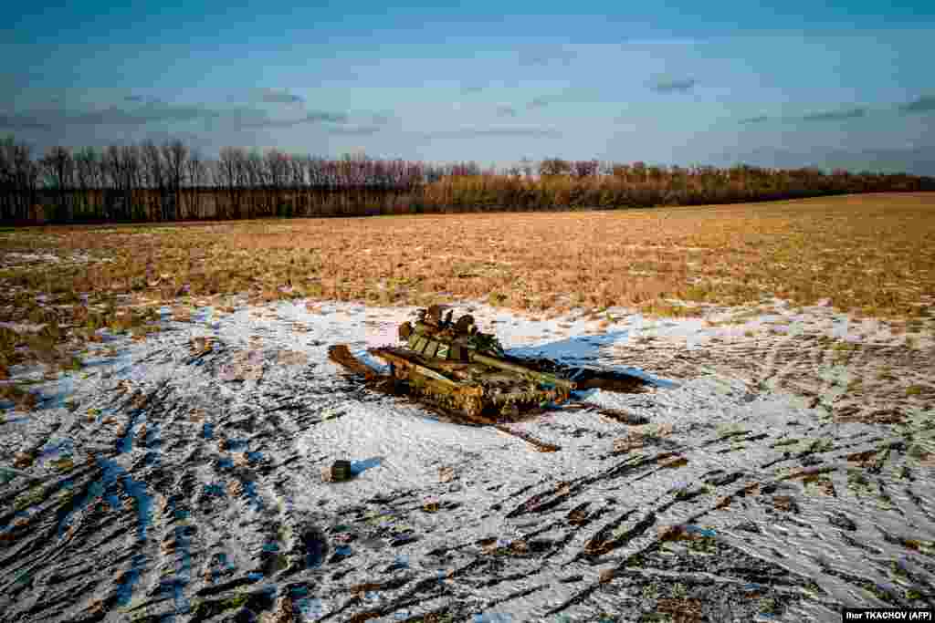 A destroyed Russian tank sits in a snow covered wheat field in the Kharkiv region.