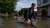 Local resident Tetyana holds her pets, Tsatsa and Chunya, above the floodwater as she stands inside her house in the Ukrainian port city of Kherson on June 6.&nbsp;<br />
<br />
<br />
<br />
&nbsp;