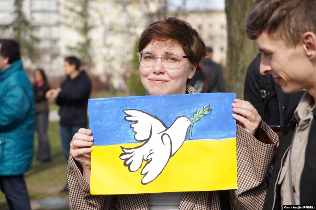 Në qytetare mban flamurin e Ukrainës të pikturuar me një pëllumb te bardhë në mes.