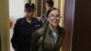 Escorted by a policewoman, Viktoria Petrova attends one of her trial hearings. By posting anti-war messages on social media, she has been accused of spreading "false" information about the Russian Army.

