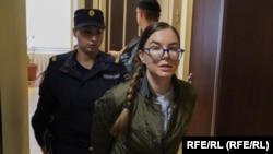 Escorted by a policewoman, Viktoria Petrova attends one of her trial hearings. By posting anti-war messages on social media, she has been accused of spreading "false" information about the Russian Army.
