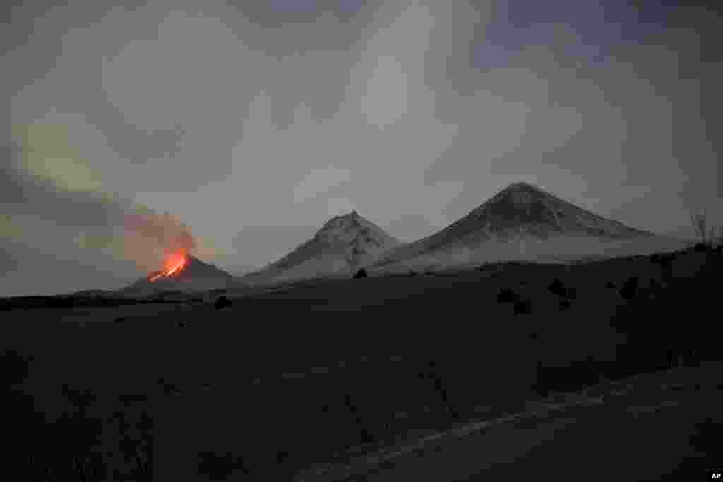 Lava and steam are visible during an eruption of the Bezymianny volcano (left) beside the Kamen (center) and Klyuchevskaya Sopka volcanoes on the Kamchatka Peninsula on April 8. The Kamchatka Peninsula, in Russia&#39;s Far East, extends southward into the North Pacific Ocean. It is one of the most concentrated areas of geothermal activity in the world, with 160 volcanoes in the region, 29 of which are believed to be currently active.