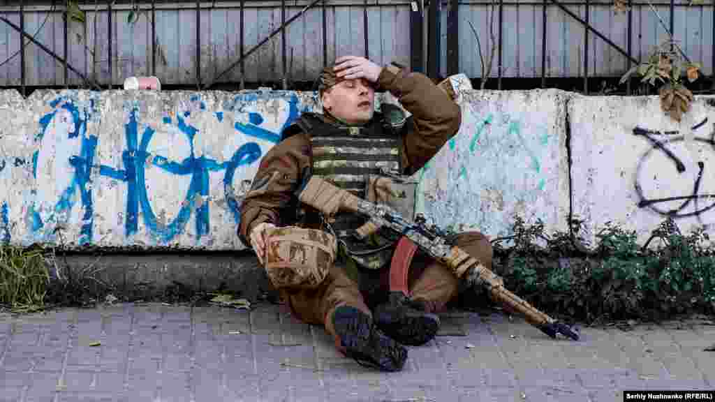 A Ukrainian soldier rests after trying to shoot down an Iranian-made Shahed-136 drone used to attack Kyiv on October 17, 2022.