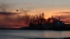 Smoke and flames fill the sky above the Crimean port of Feodosia on December 26, following a missile attack that hit a Russian landing ship.