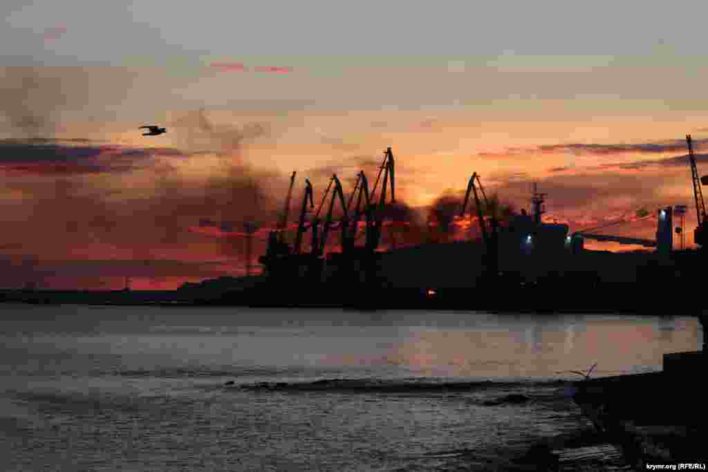 Fumul și flăcările umplu cerul dimineața devreme, deasupra portului Feodosia, pe coasta de est a Peninsulei Crimeea ocupată de Rusia, în urma unui atac cu rachete care a lovit o navă de debarcare rusă și a făcut cel puțin o victimă pe 26 decembrie. Ministerul rus al Apărării a recunoscut că nava Novocerkassk, o navă militară andocată acolo, a fost avariată.