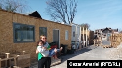Cei zece membri ai familiei Iliescu din Crevedia sunt nevoiți să locuiască în patru containere din tablă, după ce casa lor a fost distrusă de explozia din 26 august. Pentru puțin confort au improvizat un hol din prefabricate de lemn.