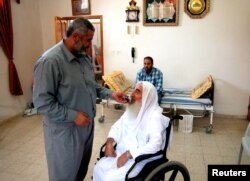 Ismail Haniyeh, actual șef al Hamas, îl ajută pe Ahmed Yassin să răspundă la un apel telefonic, în orașul Gaza, 13 iunie 2003. Co-fondatorul Hamas a trăiat cu tetraplegie de la vârsta de 12 ani, din cauza unui accident în timp ce făcea sport.