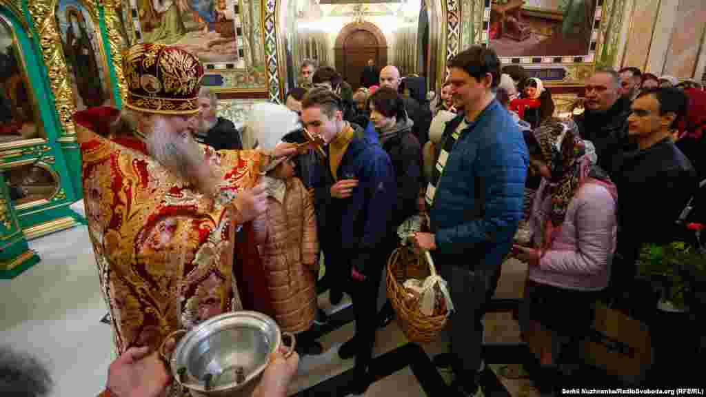 Священник освячує водою вірян під час Великоднього богослужіння УПЦ (МП) у церкві преподобного Агапіта Києво-Печерської лаври