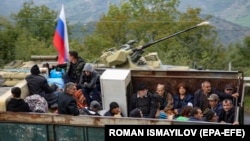 Ethnic Armenian flee Karabakh for Armenia sitting in a truck at the Lachin checkpoint controlled by Russian peackeepers and Azeri border guards, September 26, 2023. 