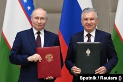 Russian President Vladimir Putin (left) and Uzbek President Shavkat Mirziyoev pose at the Kuksaroy Presidential Palace in Tashkent on May 27.