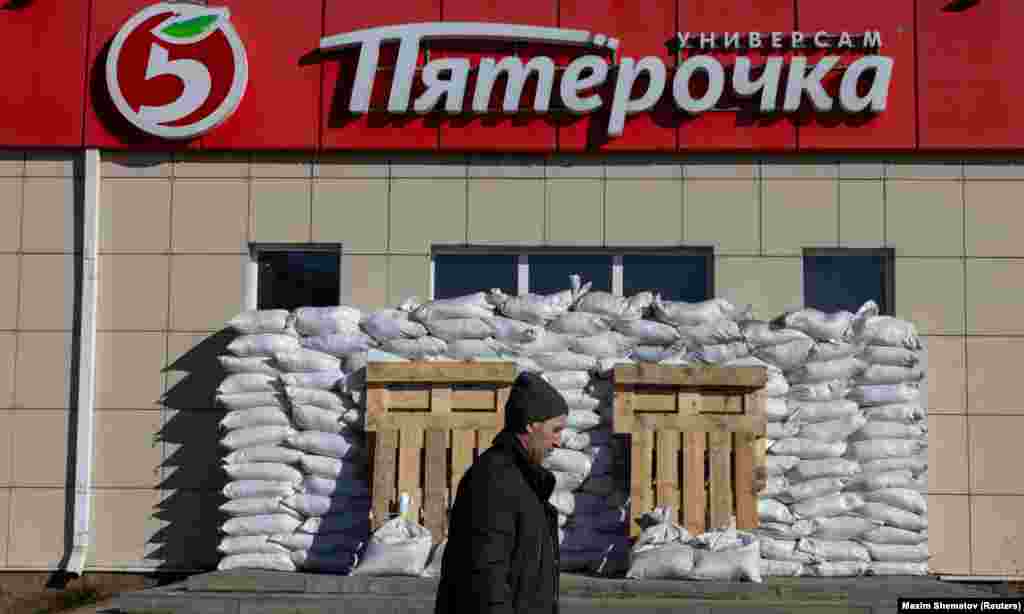 A man walks by a fortified supermarket in the course of the Russia-Ukraine conflict in the town of Shebekino in the Belgorod region of Russia.
