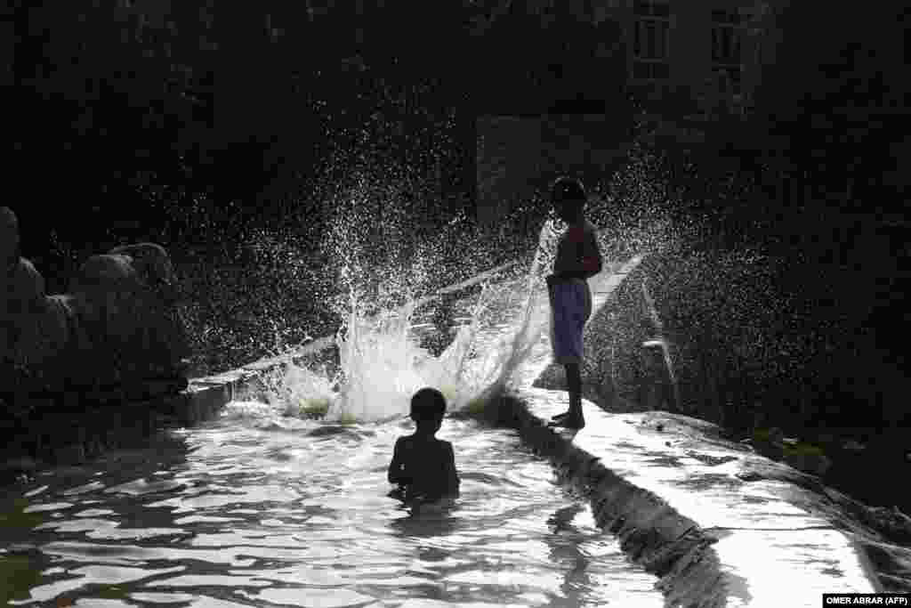  Afghan boys play in a canal in the Fayzabad district of Badakhshan Province. &nbsp; 