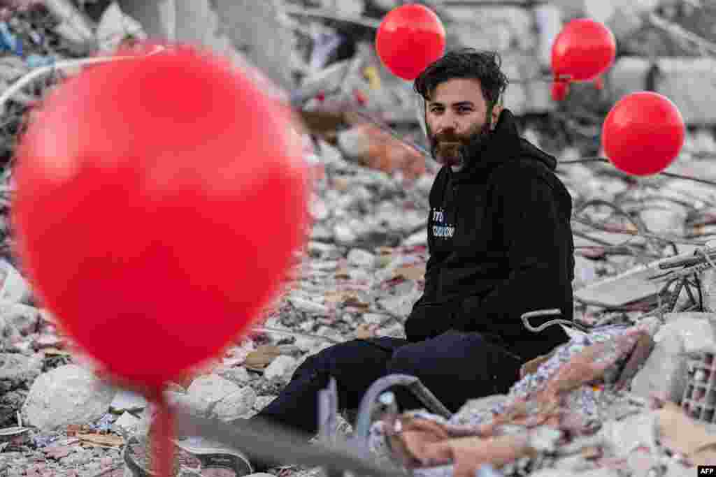 Ogun Sever Okur, 38-vjeçar, mes balonave të varur në rmbetjet e rrënojave të një ndërtese të shembur në Antakya, Turqi.