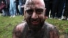 A participant covered in mud reacts as he takes part in the ancient game of lelo burti (field ball) in the village of Shukhuti in the Guria region of Georgia during Orthodox Easter celebrations. The brutal folk game has no limit on the number of participants or the match time, nor is there a referee.