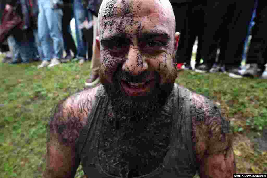 A participant covered in mud reacts as he takes part in the ancient game of lelo burti (field ball) in the village of Shukhuti in the Guria region of Georgia during Orthodox Easter celebrations. The brutal folk game has no limit on the number of participants or the match time, nor is there a referee.