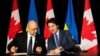 Ukrainian Prime Minister Denys Shmyhal (left) signs documents with his Canadian counterpart, Justin Trudeau, in Toronto, on April 11. 