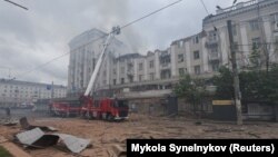 Firefighters work at a site of an apartment building hit by a Russian missile strike in Dnipro on April 19.