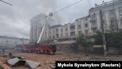 Firefighters work at a site of an apartment building hit by a Russian missile strike in Dnipro on April 19.