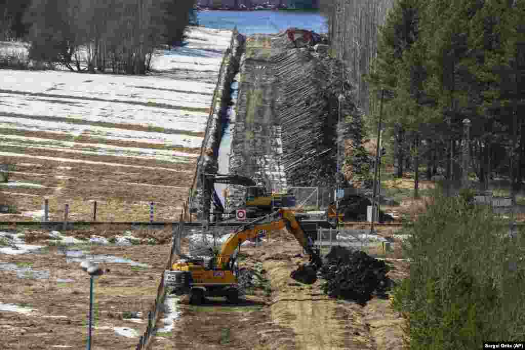 În apropierea punctului de trecere a frontierei finlandeze Pelkola cu Rusia, 14 aprilie. Excavatoarele lucrează la pregătirea unei fâșii de frontieră pentru un nou gard de delimitare. Un stâlp verde cu roșu care marchează teritoriul rusesc poate fi văzut în partea stângă a acestei fotografii.