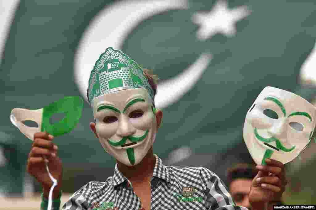 A Pakistani vendor in Karachi sells decorative masks and items with colors of the national flag as the nation prepares to celebrate Independence Day. Pakistan celebrates the 76th anniversary of its independence from British rule in 1947 on August 14.