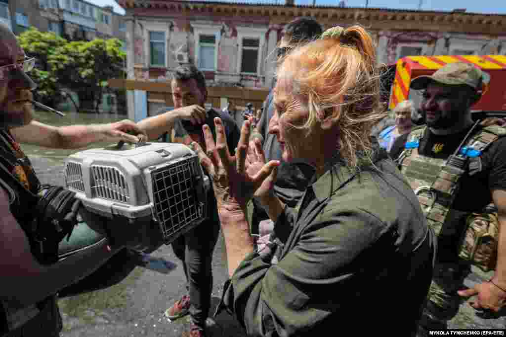 A woman reacts as volunteers remove pets from a boat following their rescue.