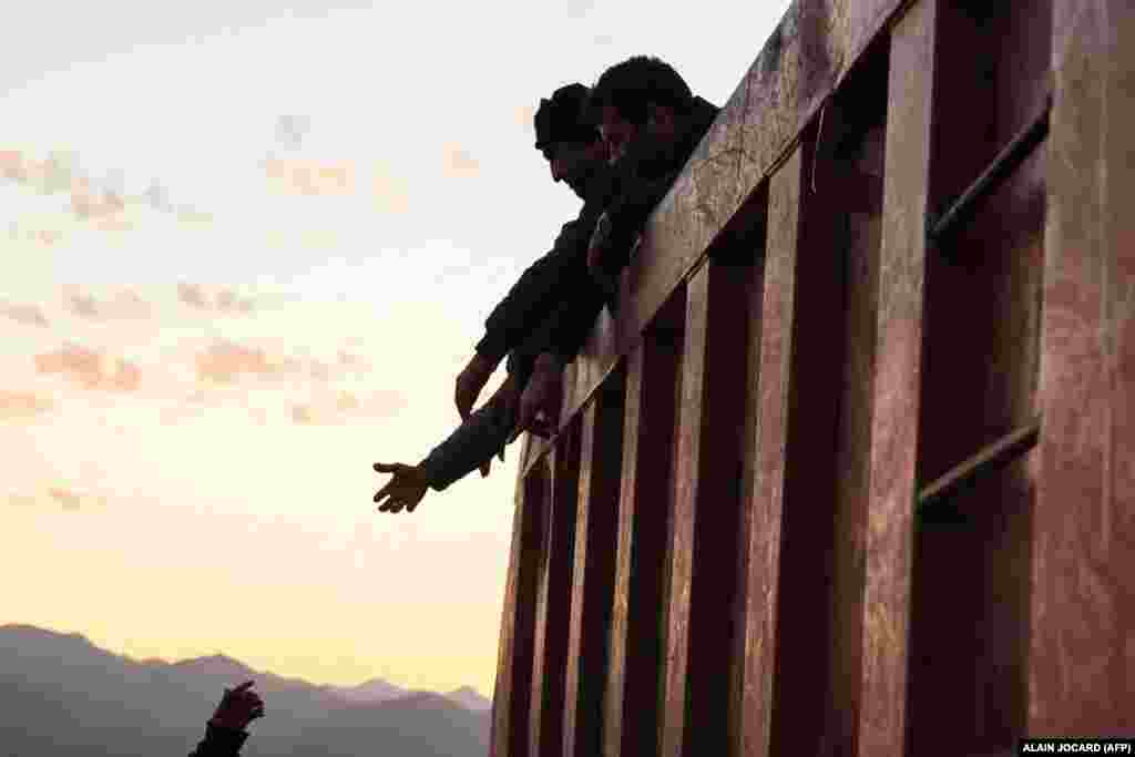 Refugees fleeing Nagorno-Karabakh reach out to one another from the back of a truck after crossing the border near Kornidzor, Armenia.