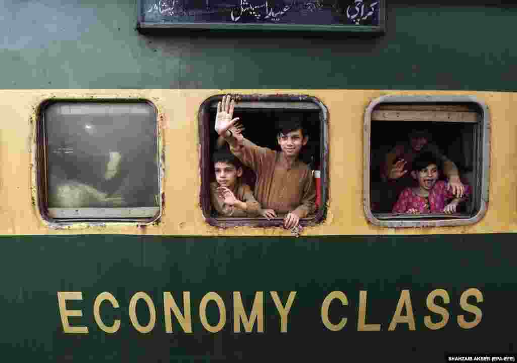 Children wave from a train as they prepare to travel to their homes to celebrate Eid al-Fitr in Karachi, Pakistan. Eid al-Fitr is an Islamic holiday that marks the end of Ramadan.