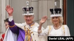 Regele Charles al III-lea al Marii Britanii și regina Camilla a Marii Britanii salută mulțimea de la balconul Palatului Buckingham, după ceremonia de încoronare. Londra, 6 mai 2023.