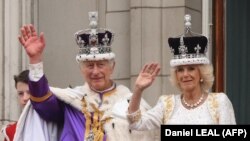 Kralj Čarls Treći i kraljica Kamila mašu sa balkona Bakingemske palate u Londonu, 6. maj 2023. 